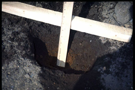 Figure 3.1. Subsurface re-crystallization of explosives found between burning trays at an ordnance works facility. Note: The orange-colored soil at the bottom of the pit contains percent levels of TNT.