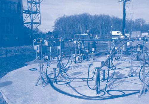 Figure 2. TCH equipment at NAWC includes thermal conduction heaters controlled through silicon-controlled rectifiers plus vapor extraction wells connected to a central vapor manifold via flexible hoses. Concrete cover at ground surface provides vapor control and reduces rain infiltration into the treatment zone.
